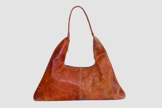 Bolso de cuero marrón estilo casual con asa larga, fondo gris claro