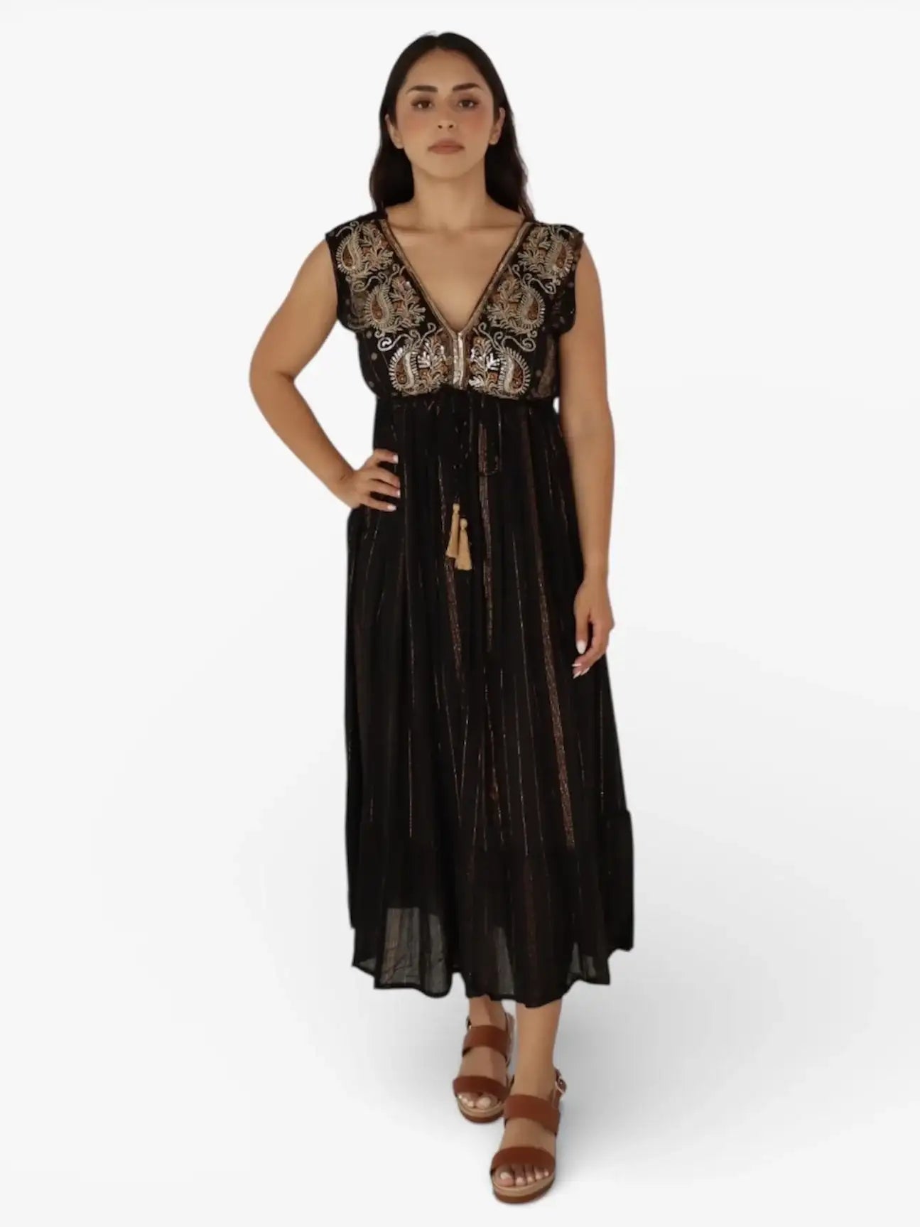 Mujer con vestido largo negro, bordado dorado y sandalias marrón, moda elegante latinoamericana