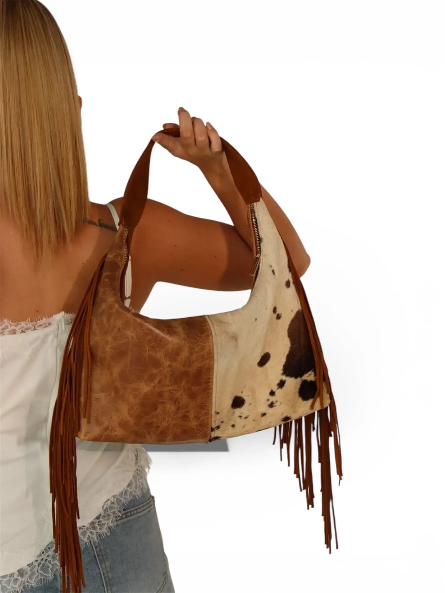 Bolso de mujer tipo hobo en cuero café claro con flecos y estampado de animal print, estilo western