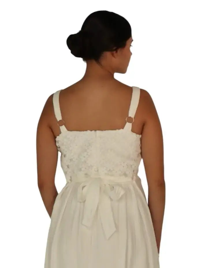 Mujer de espaldas con vestido blanco de tirantes y lazo, estilo elegante y femenino