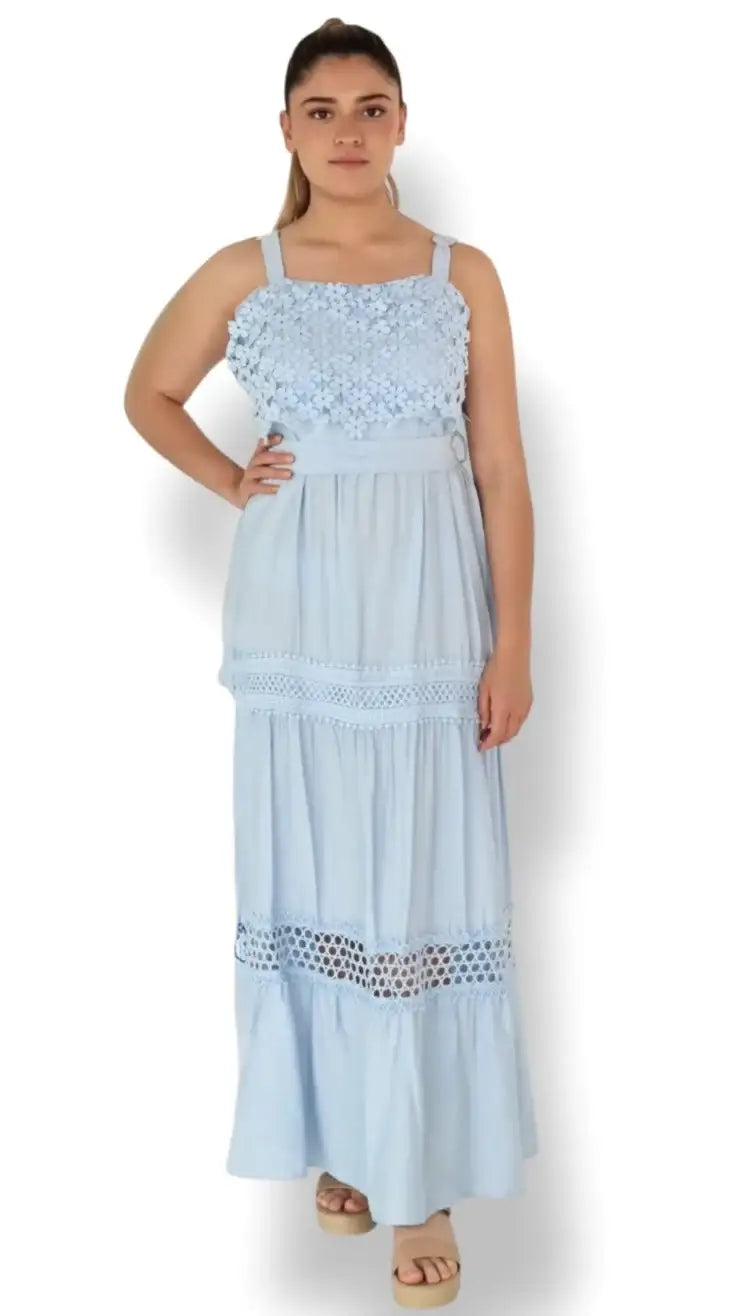 Mujer con vestido largo azul claro de tirantes y detalles de encaje, estilo fresco y moderno.