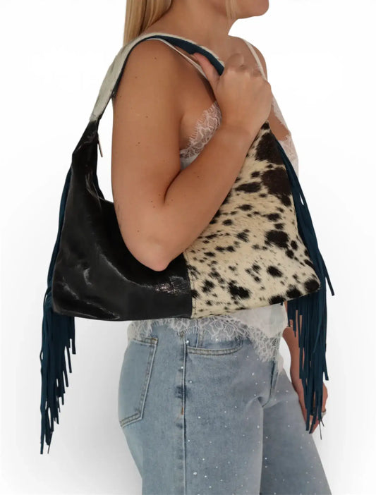 Bolso de hombro estilo western, bicolor con estampado animal print y flecos, mujer de perfil