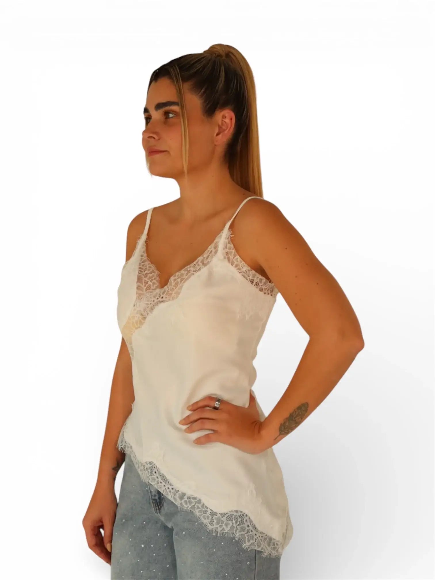 Mujer usando blusa de tirantes blanca con encaje y jeans, moda casual femenina