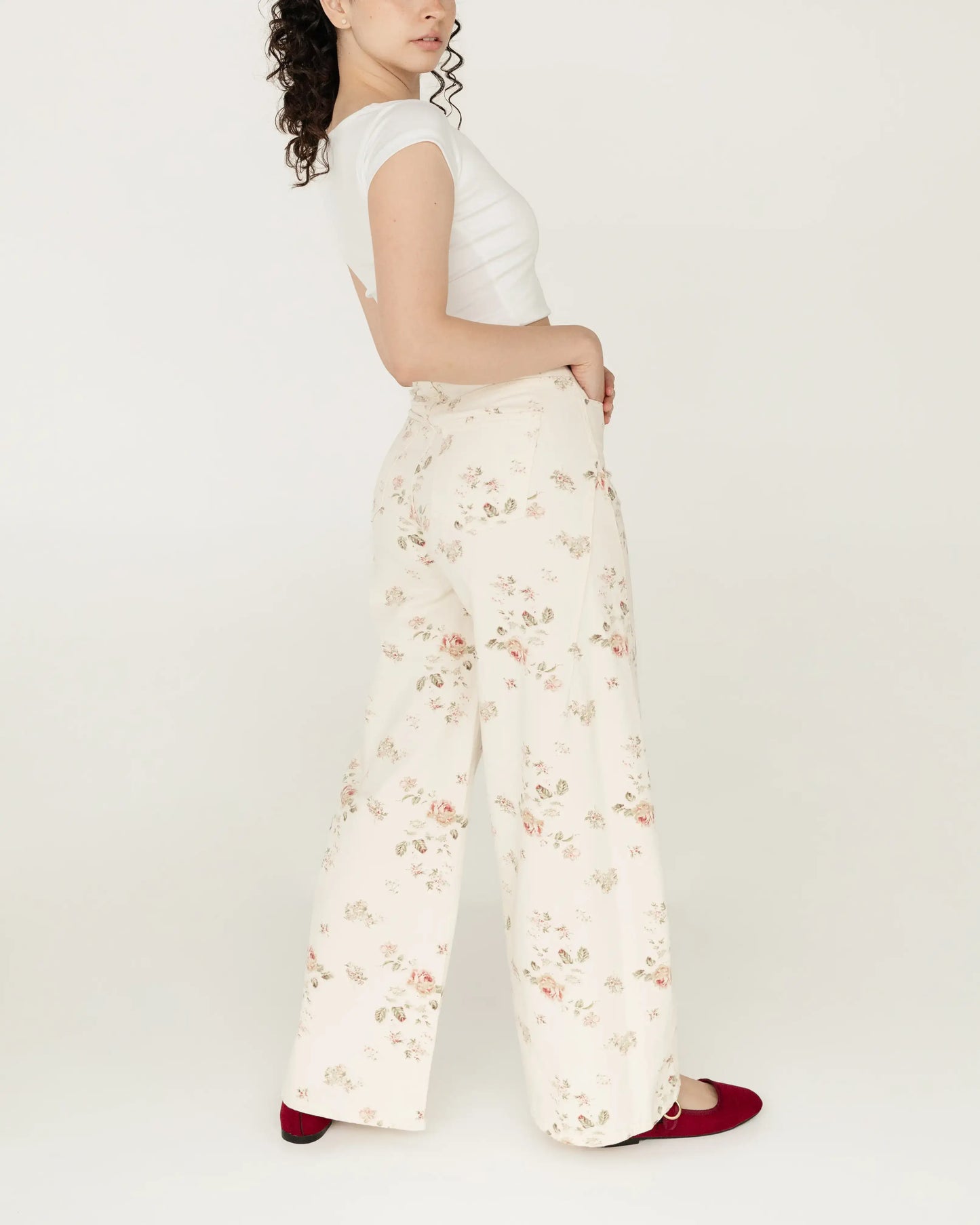 Mujer con pantalón blanco de flores y blusa blanca, moda femenina juvenil