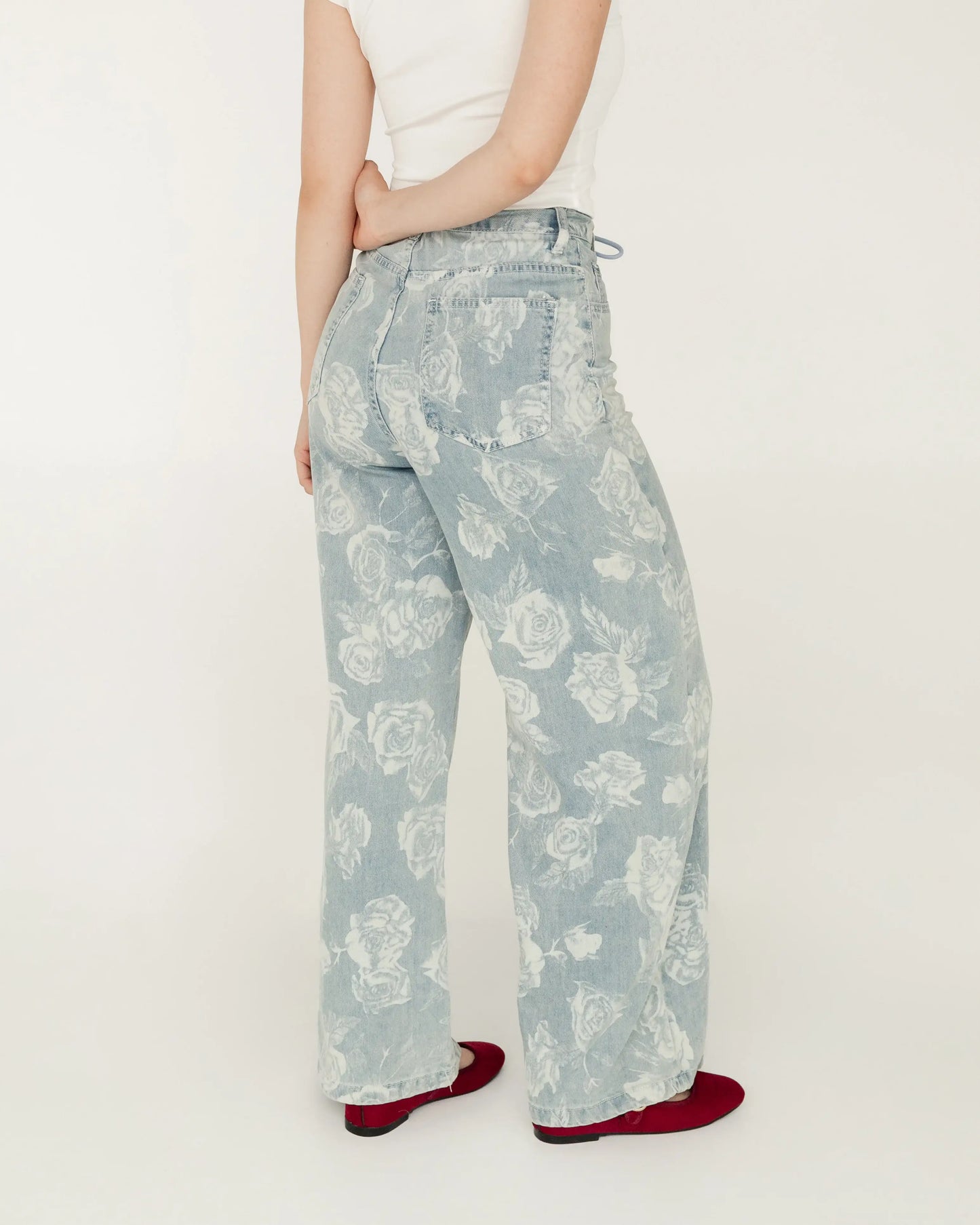 Pantalón de mezclilla ancho con estampado floral, mujer de perfil, estilo moderno