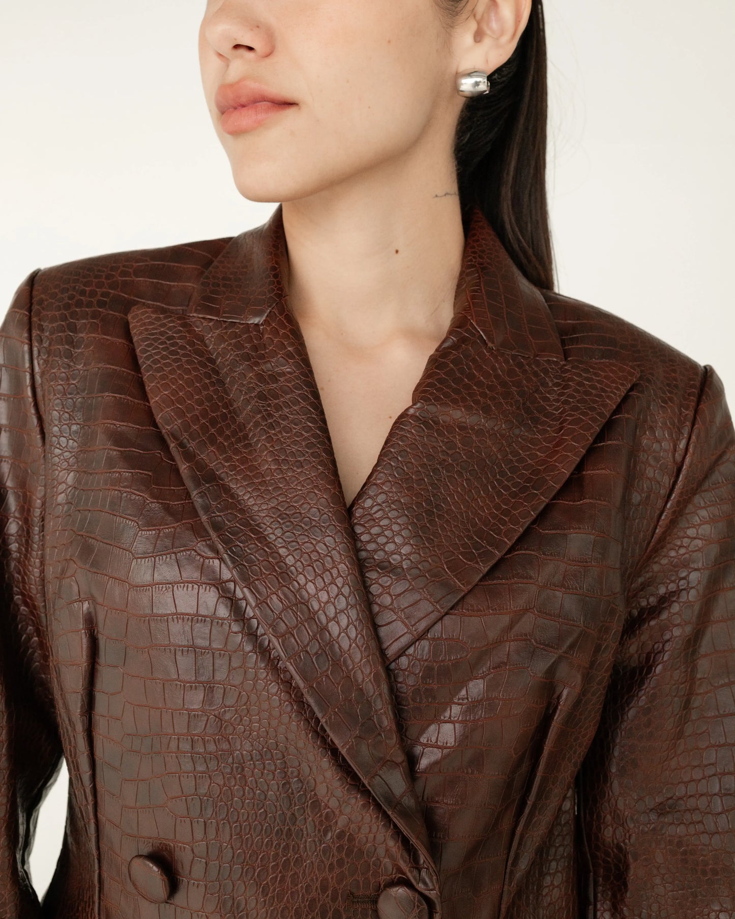 Mujer con saco marrón efecto piel de cocodrilo, estilo elegante y moderno