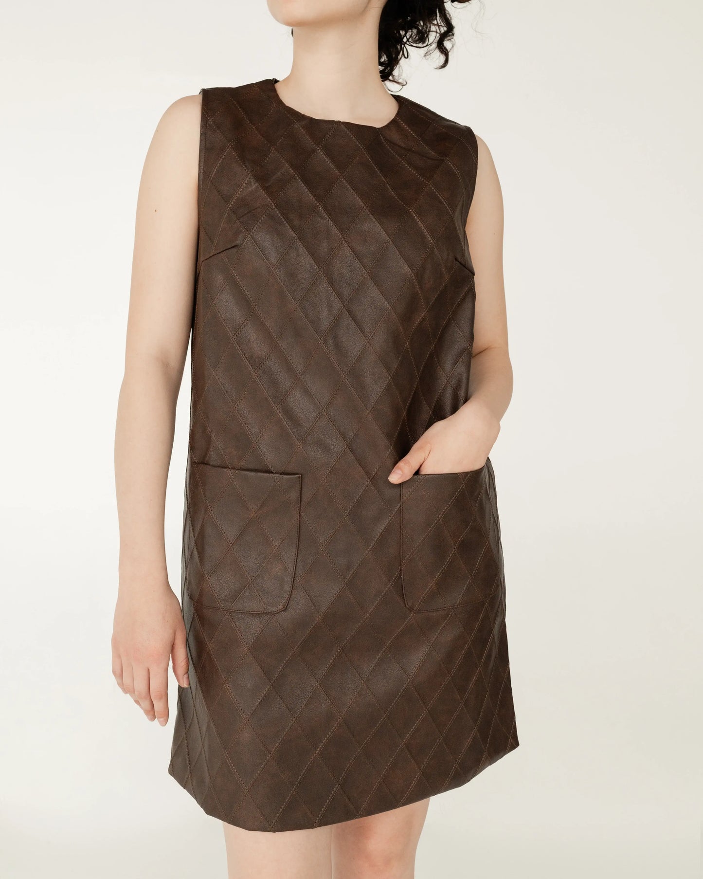 Vestido corto sin mangas color marrón con textura acolchada y bolsillos frontales