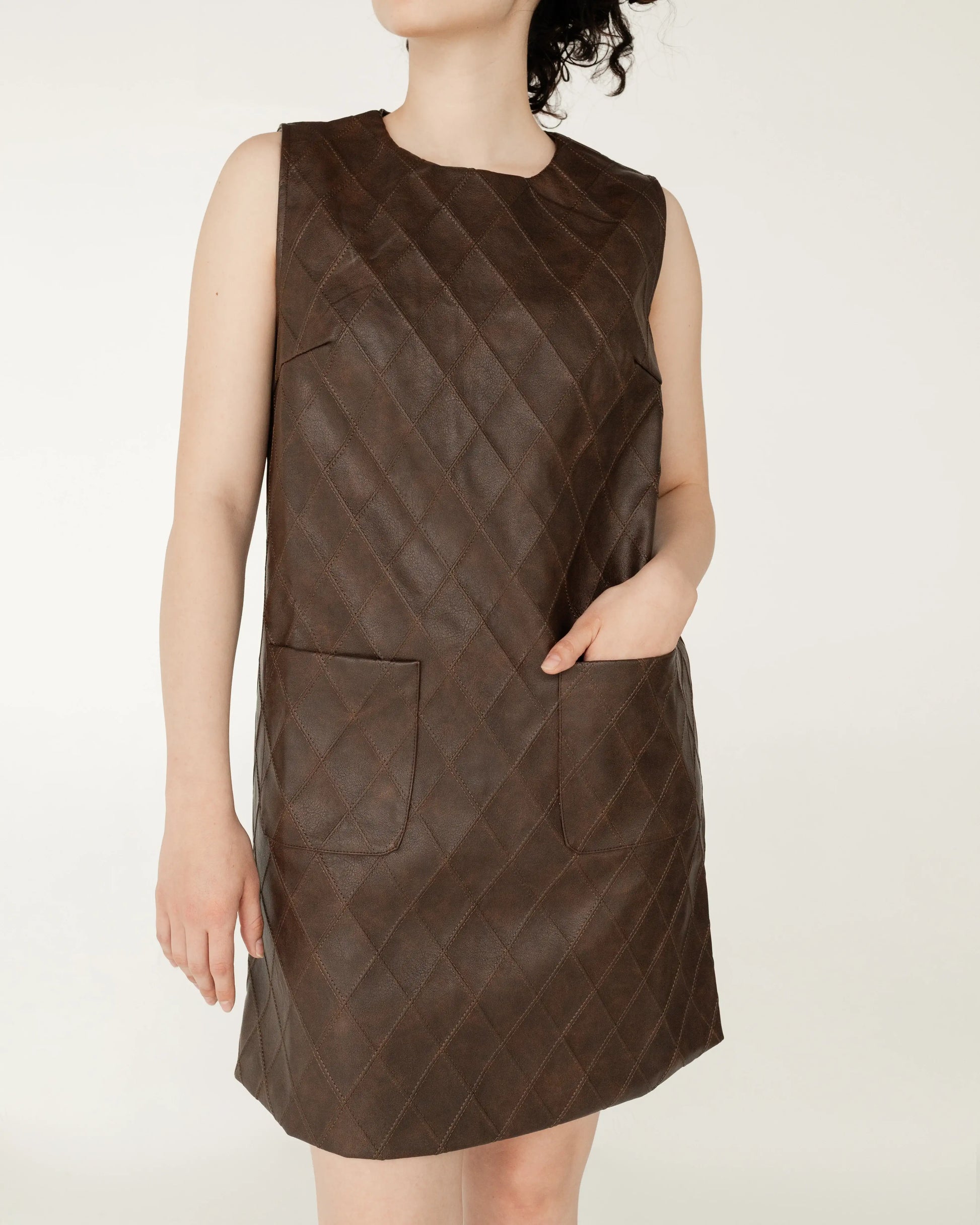 Vestido corto sin mangas color marrón con textura acolchada y bolsillos frontales