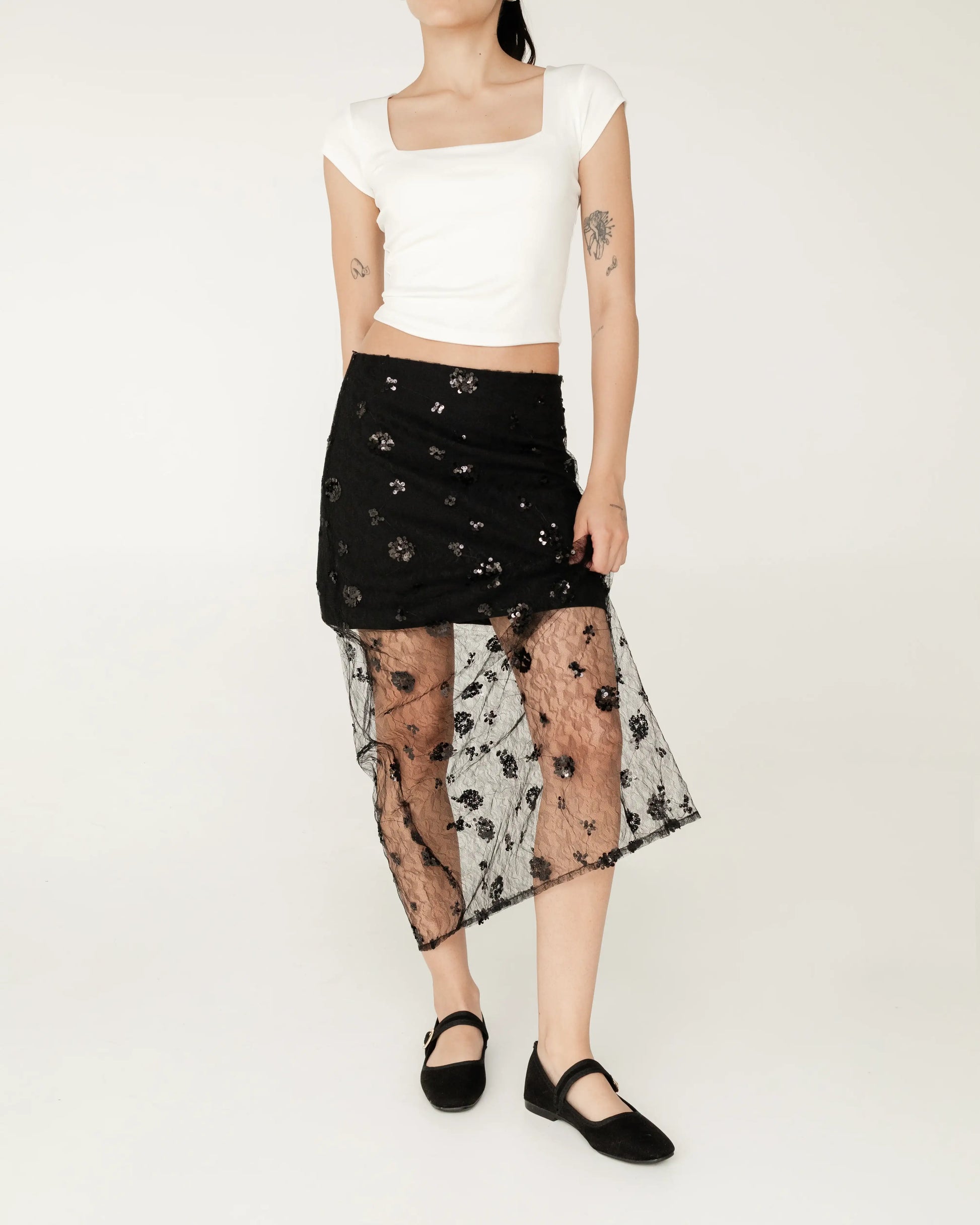 Falda negra midi con encaje transparente floral, blusa blanca corta, moda femenina elegante