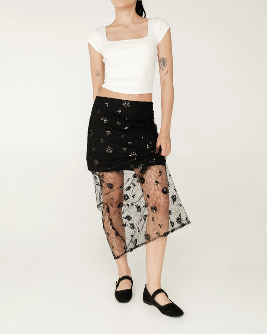 Falda negra midi con encaje transparente floral, blusa blanca corta, moda femenina elegante