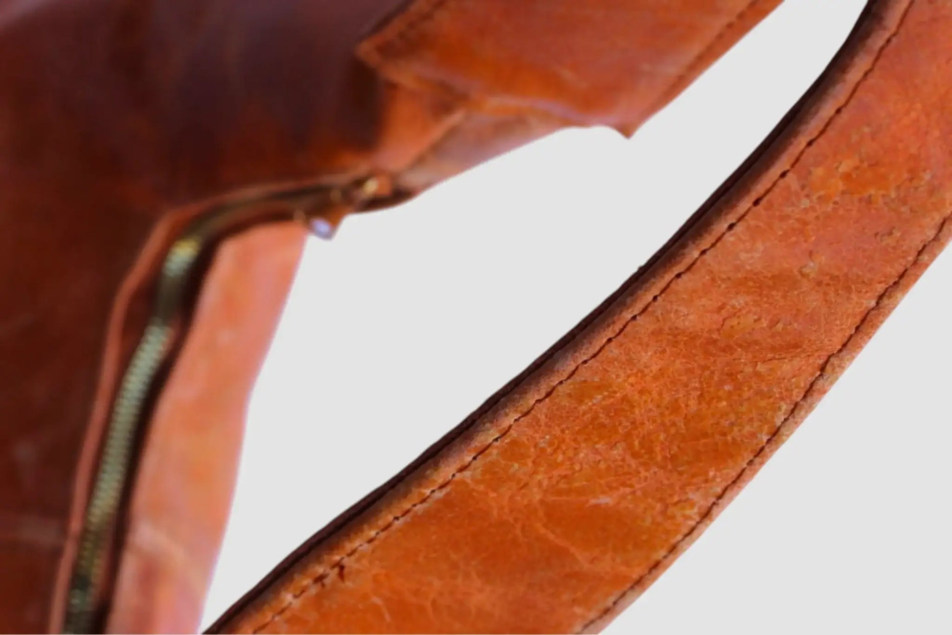 Detalle de asa y cierre metálico de bolso de piel color marrón